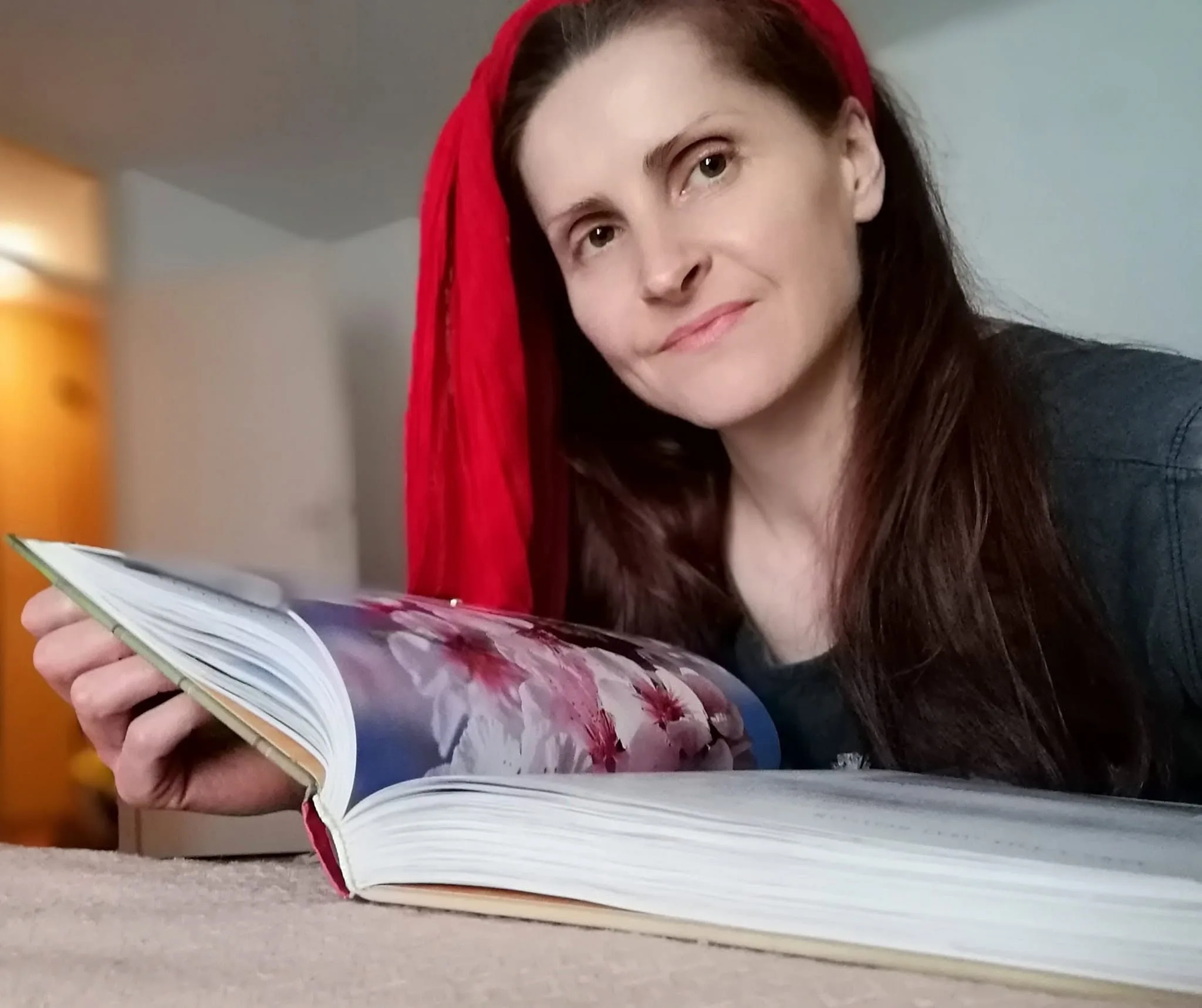 Jelena Stevanović, portret sa otvorenom knjigom i crvenom maramom.